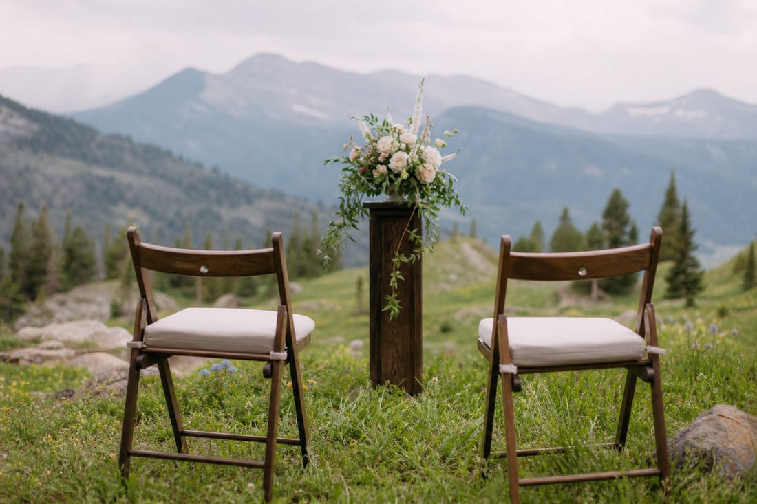Beispiel: zwei leere Stühle und Blumenpodest für ein Elopement